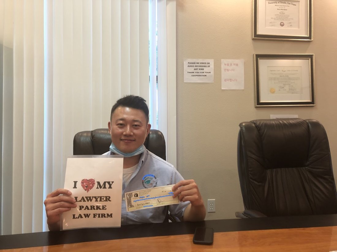 A Parke Injury Law client holding an I Love My Lawyer sign